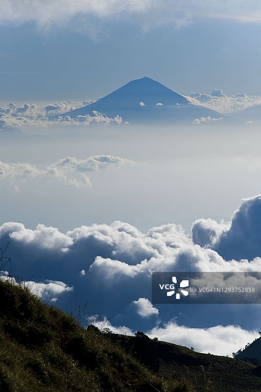 阿贡火山，巴厘岛上最高的火山，从营地高高升起在云端之上，这是为期三天的林贾尼山徒步旅行的第一天，印度尼西亚，亚洲龙目岛图片素材