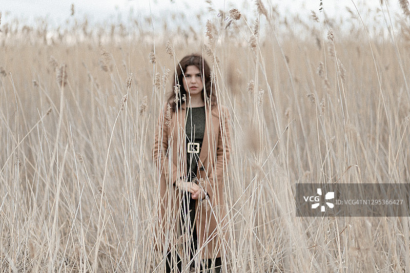一个塔吉克妇女站在芦苇丛里图片素材