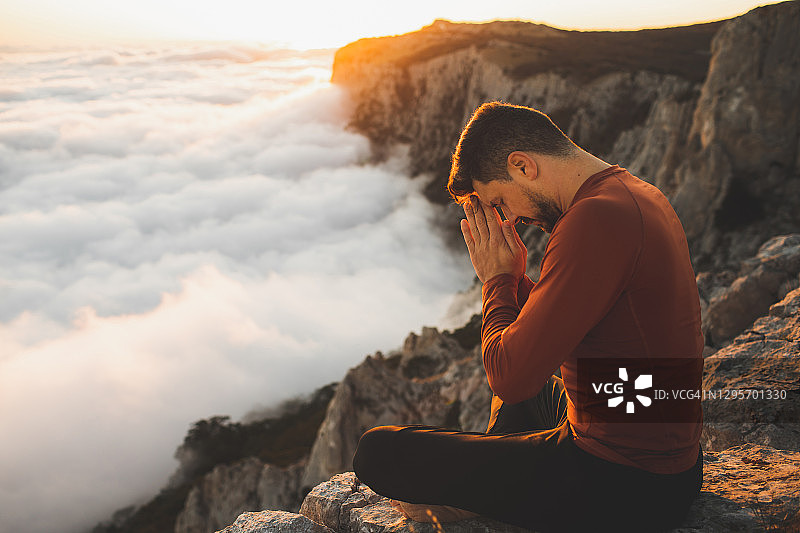 一个人在早晨独自在山外祈祷。觉醒，与自然和谐相处图片素材