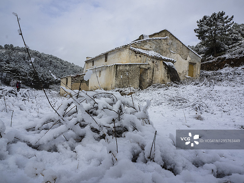 冬天的雪景和一个废弃的乡村房子。图片素材