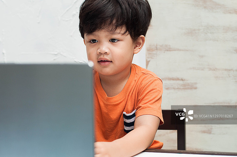 一名东南亚幼童正在用笔记本电脑在家上电子学习课图片素材