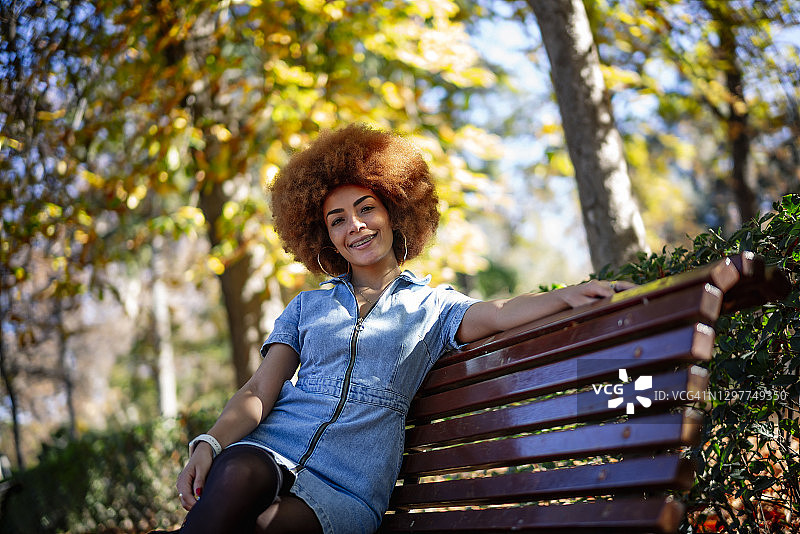 坐在公园长椅上的快乐女人图片素材