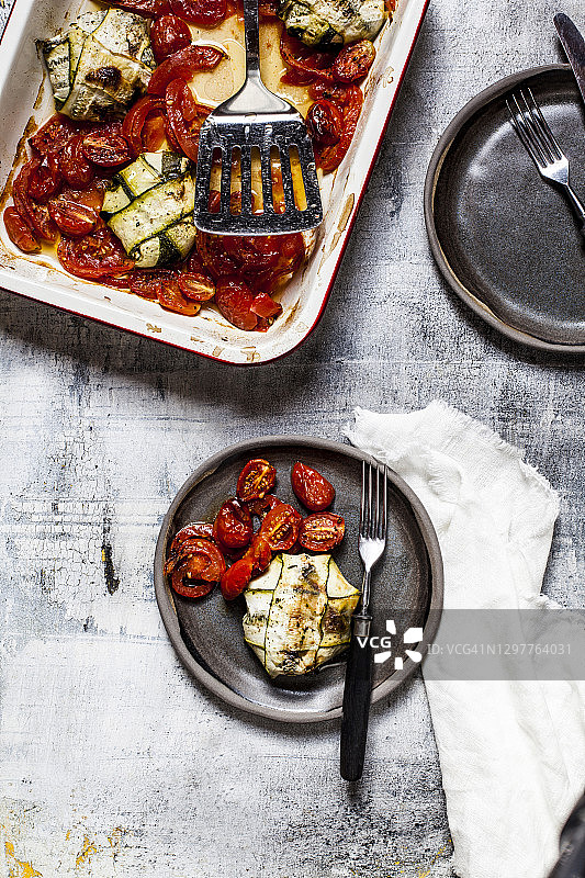 烤番茄，菠菜和羊乳酪填馅的西葫芦馄饨，用叉子放在盘子里图片素材