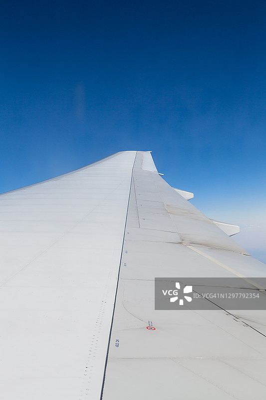 日落时透过飞机窗口的机翼视图图片素材