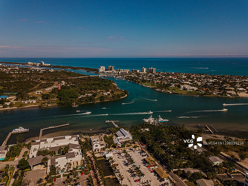 在佛罗里达州朱庇特海滩上的朱庇特灯塔在蓝绿色海水上移动的船只的周末鸟瞰图，在2021年1月的中午图片素材