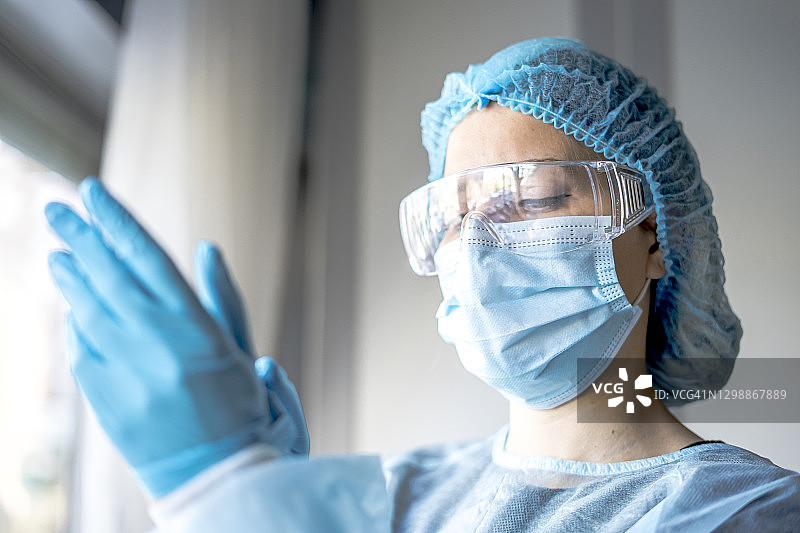 医学和外科主题:医生戴上防护蓝手套图片素材