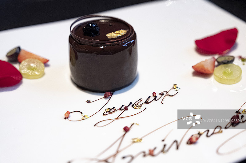 一个用文字和玫瑰装饰的巧克力生日蛋糕图片素材