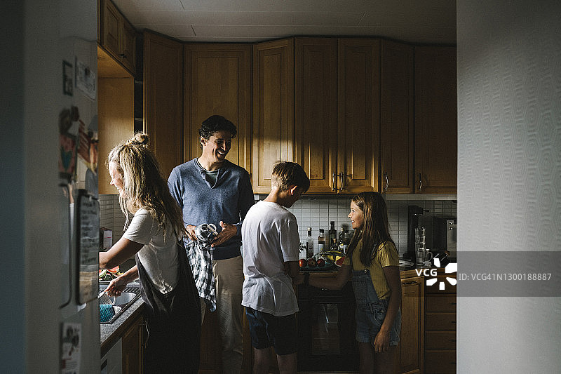 快乐的家庭在厨房里做家务图片素材