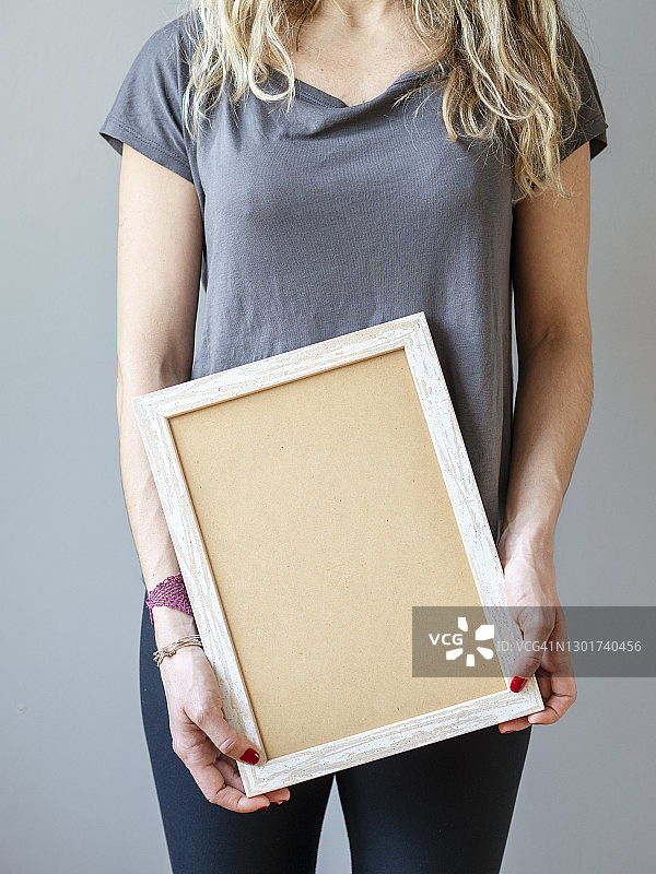 一个空着白色镜框，空白广告牌的女人图片素材