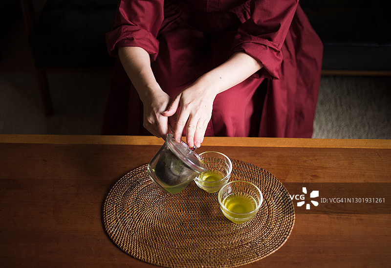 亚洲妇女在家里享受茶道图片素材
