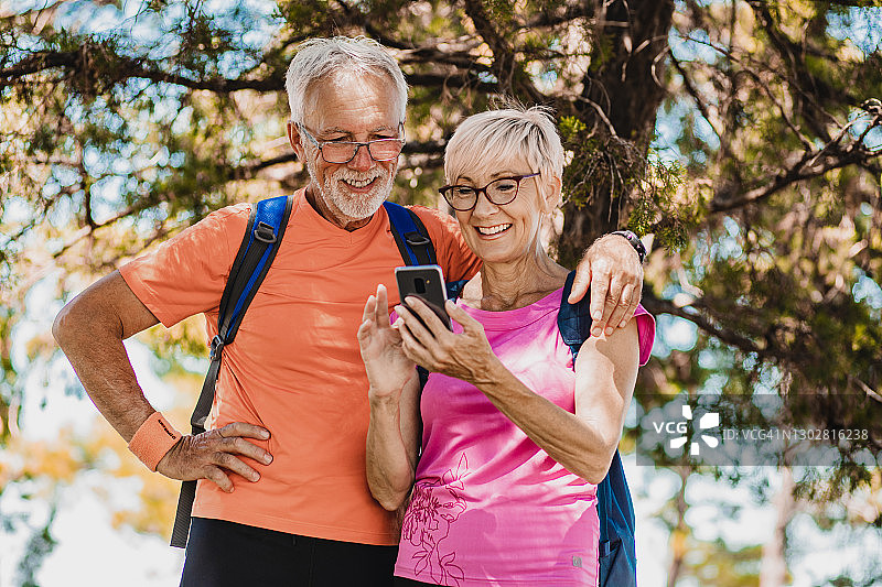 喜欢远足和使用手机的运动老年人图片素材