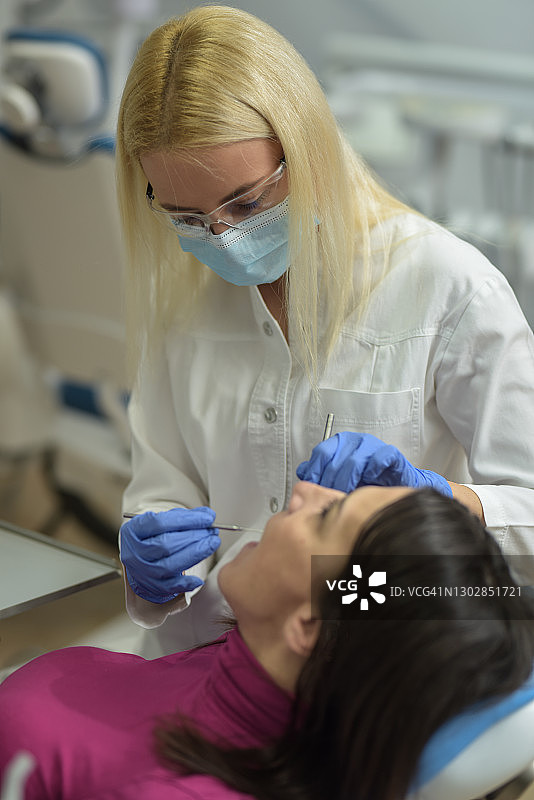 女牙医正准备为她的病人做口腔检查图片素材