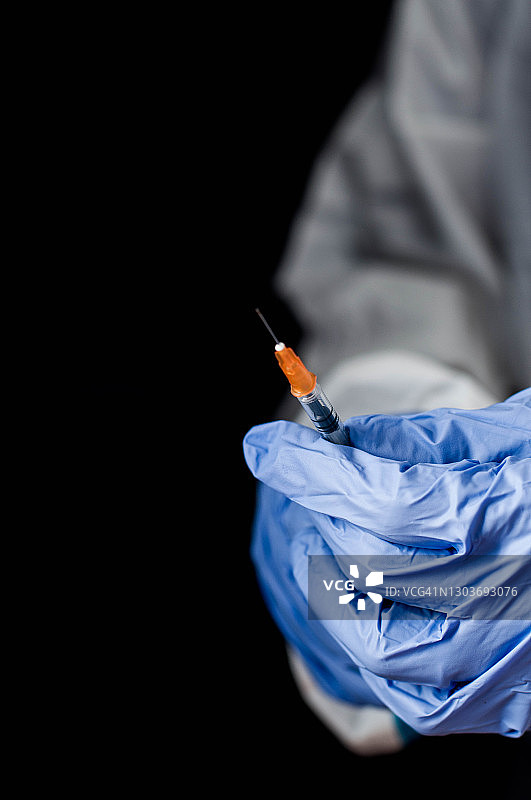 医护人员手持医疗注射器接种疫苗的特写镜头图片素材