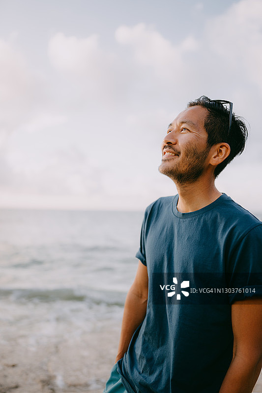 日落时分，一个日本男人在海滩上的肖像图片素材