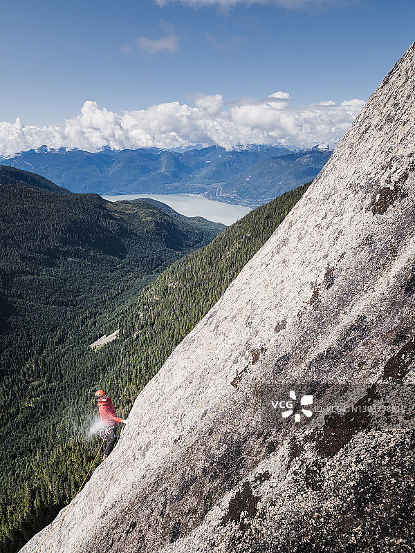 攀岩者在攀登BC省斯阔米什附近的一个高高的、偏僻的岩面时，将手放在粉笔袋里图片素材