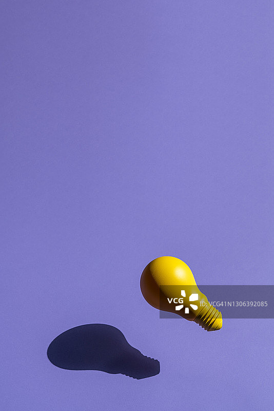 黄色白炽灯灯泡在紫色的背景图片素材