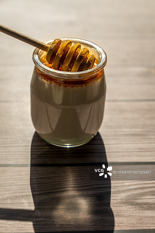 木头桌子上的蜂蜜酸奶图片素材