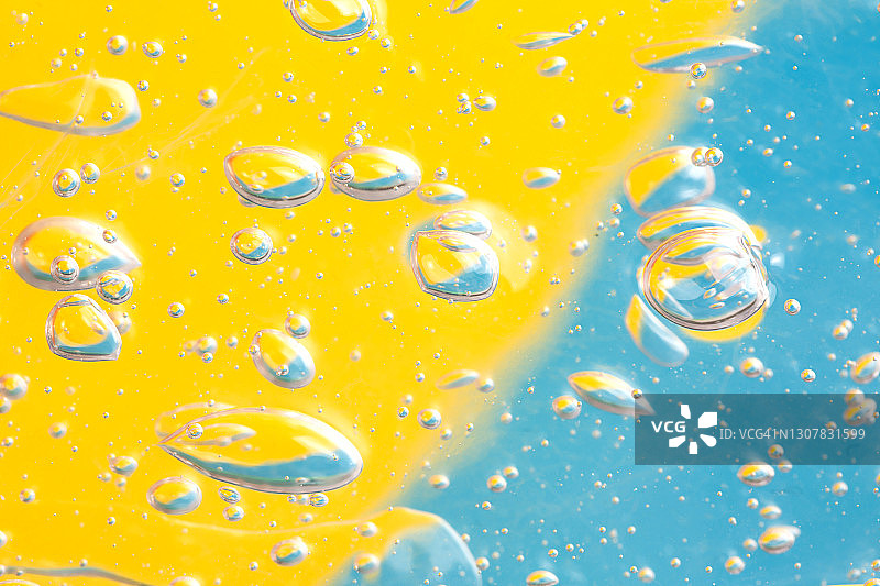 有机透明凝胶或保湿乳液的质地与许多气泡的背景分开照亮黄色和淡蓝色部分。Covid-19大流行期间的疾病预防概念。特写和平铺风格与复制空间图片素材