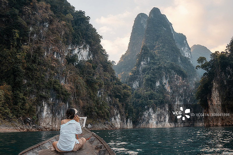 东南亚国家公园ratchaprapha大坝，青年游客乘坐长尾船游览泰国。图片素材
