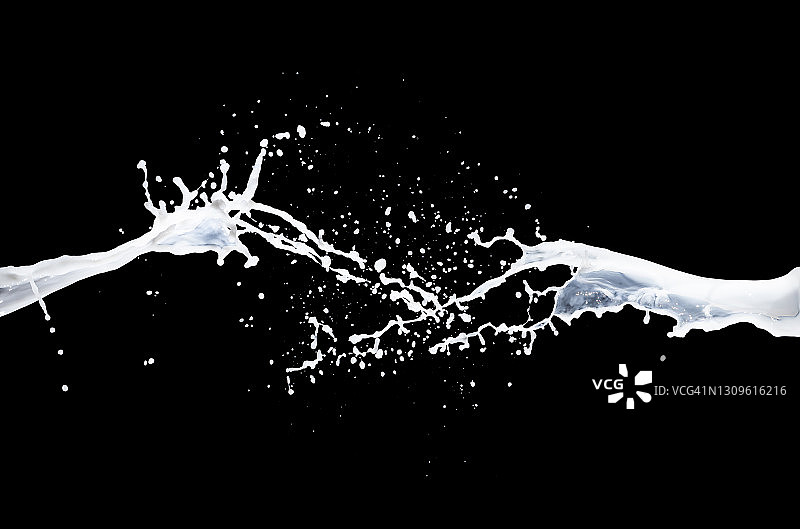 白色液体(牛奶)在黑色背景上产生飞溅和掉落的震动。图片素材