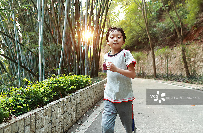 小男孩在公园里跑步图片素材