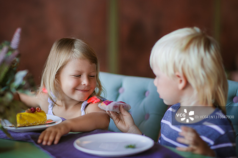 女孩和男孩在咖啡馆吃蛋糕的照片图片素材