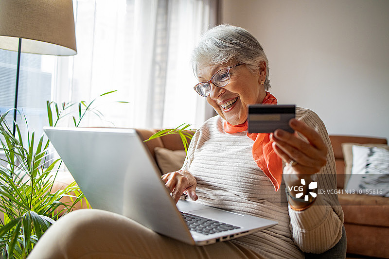 年长的女人在笔记本电脑上放松和网购图片素材