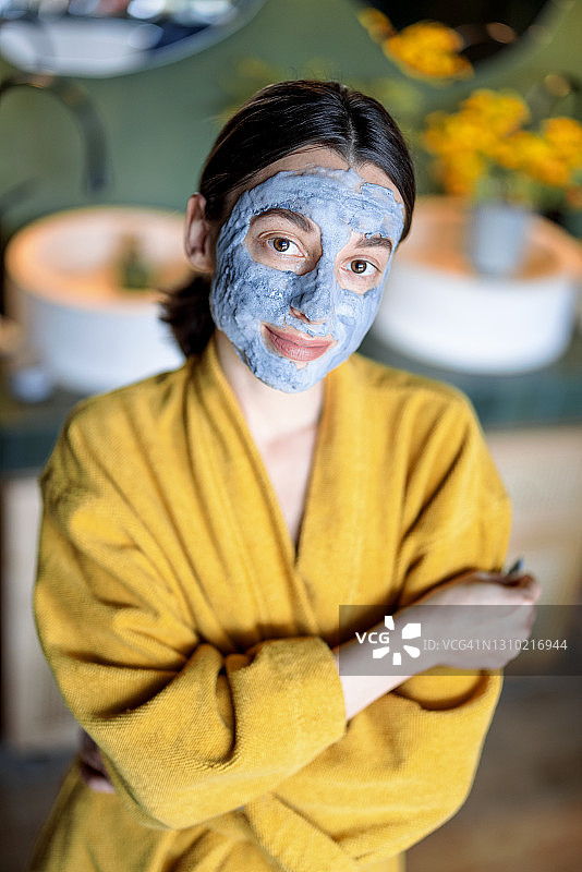 一个年轻女子的肖像与泡沫清洁面膜在她的脸上图片素材