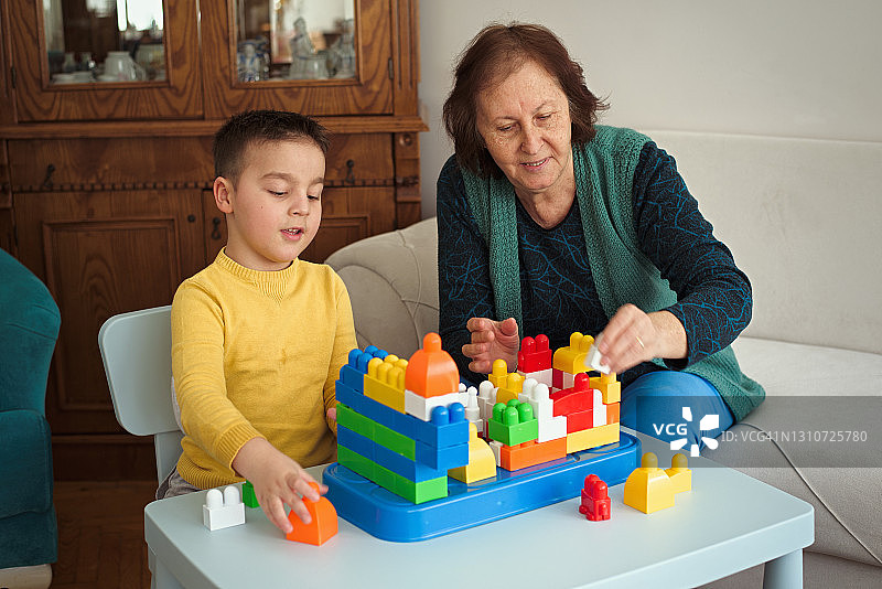 奶奶和孙子在家里玩积木图片素材