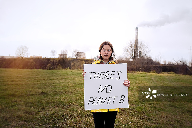 一个少女拿着一张关于气候变化的海报图片素材