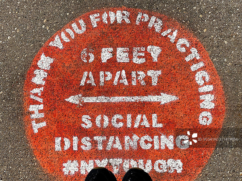 社交距离提醒鞋尖印在沥青路面上图片素材