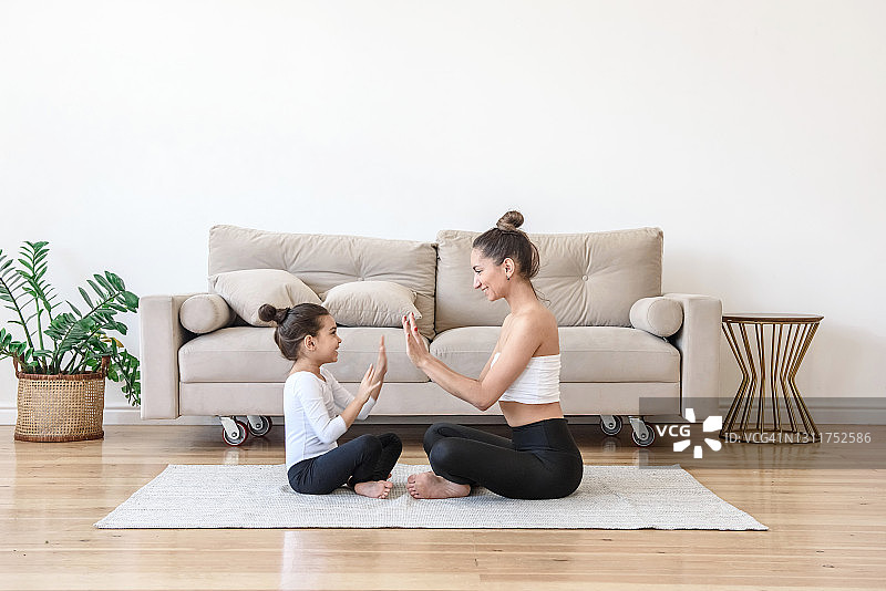 幸福的家庭妈妈和女儿花时间一起做瑜伽和玩在家里图片素材