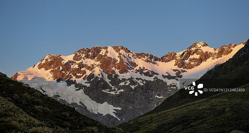 新西兰南岛坎特伯雷地区库克山国家公园日出时的塞夫顿山和脚凳峰脊图片素材