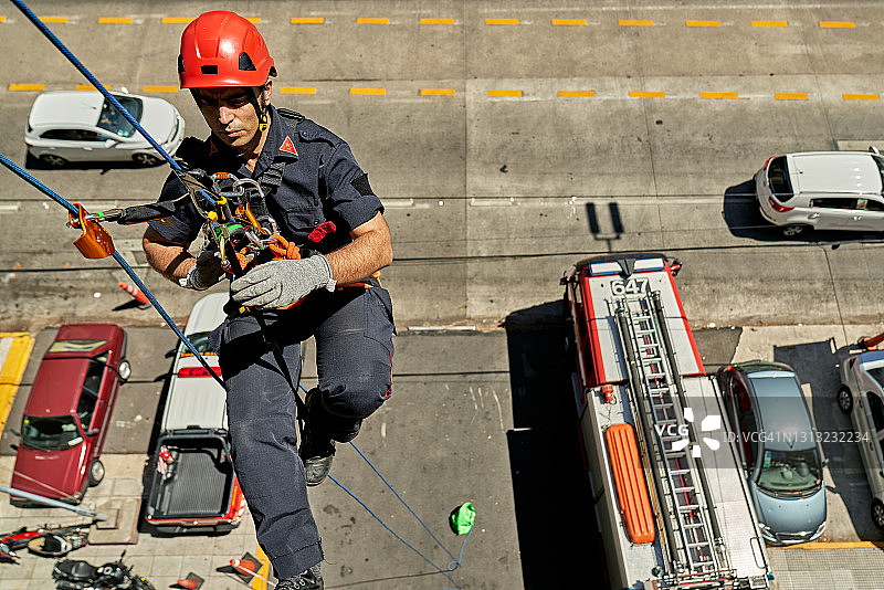 30岁后期的男消防员用绳子练习逃生系统图片素材