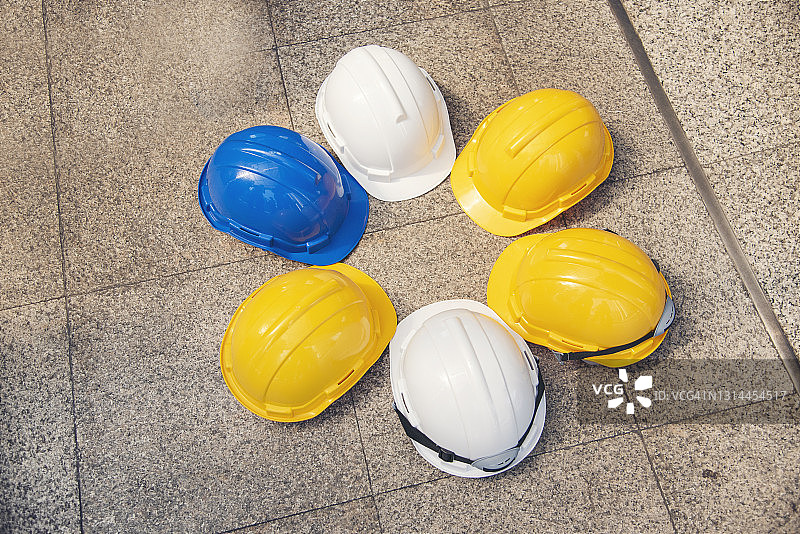 施工安全帽是施工现场工人安全工具设备的工程防护头的标准。许多安全帽上的安全帽与抄写空间。工程建设的概念图片素材