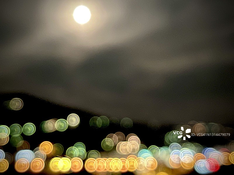 月亮下的城市灯光散焦图片素材
