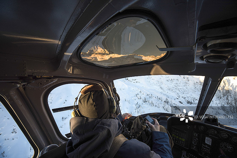 滑雪者乘坐直升机飞过雪山图片素材