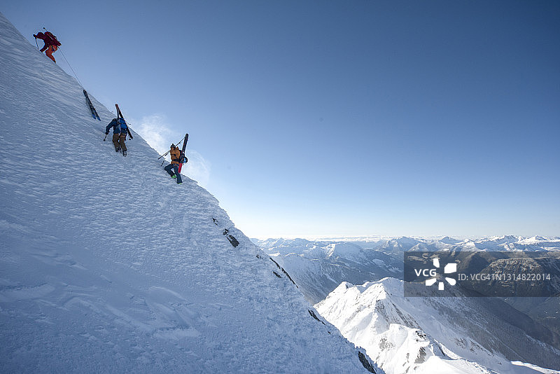 滑雪登山运动员爬陡峭的山坡图片素材