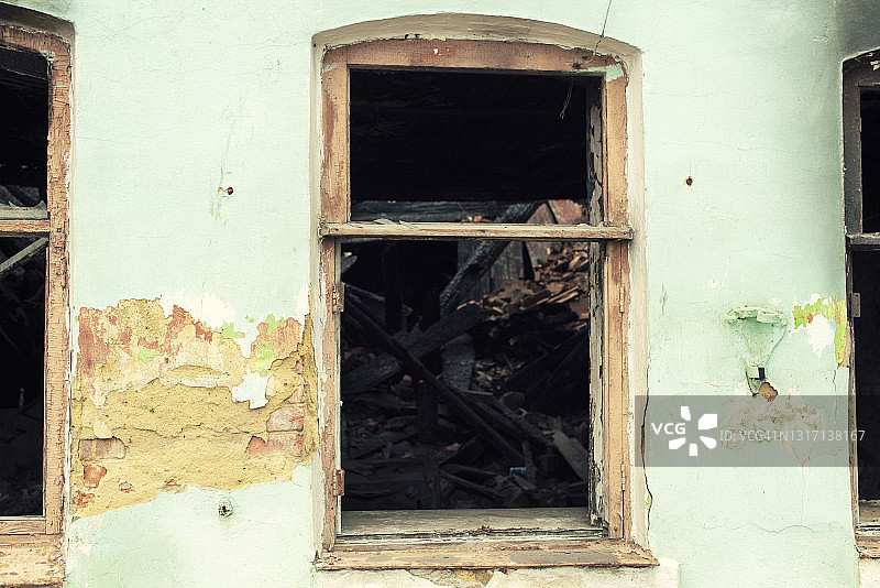 一幢被毁坏的老房子的一堵带有窗户的墙图片素材