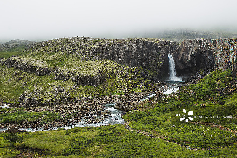 冰岛东部美丽的瀑布。戏剧性的多云的天气。图片素材