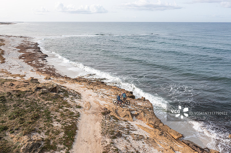 无人机拍摄的海岸线上的摩托车手图片素材