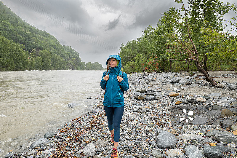 女徒步者在暴雨中享受恶劣天气下的大自然图片素材