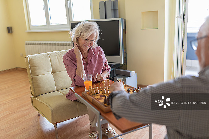老年人在家享受棋盘游戏。图片素材