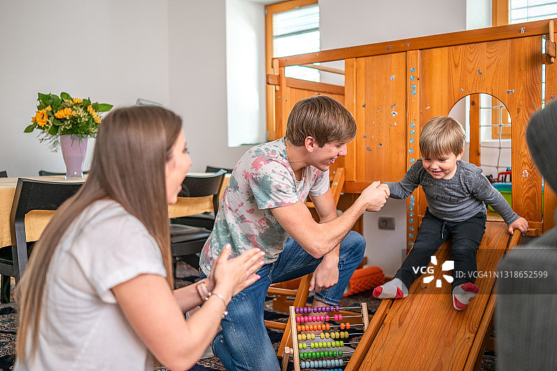 年轻的家庭和一个孩子在家里玩图片素材