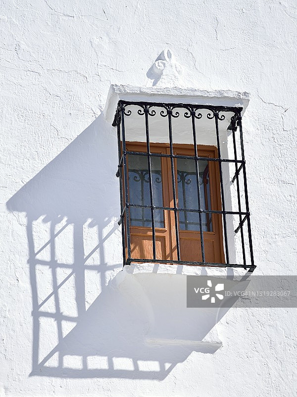 白色的外立面，有一扇带栏杆的窗户图片素材