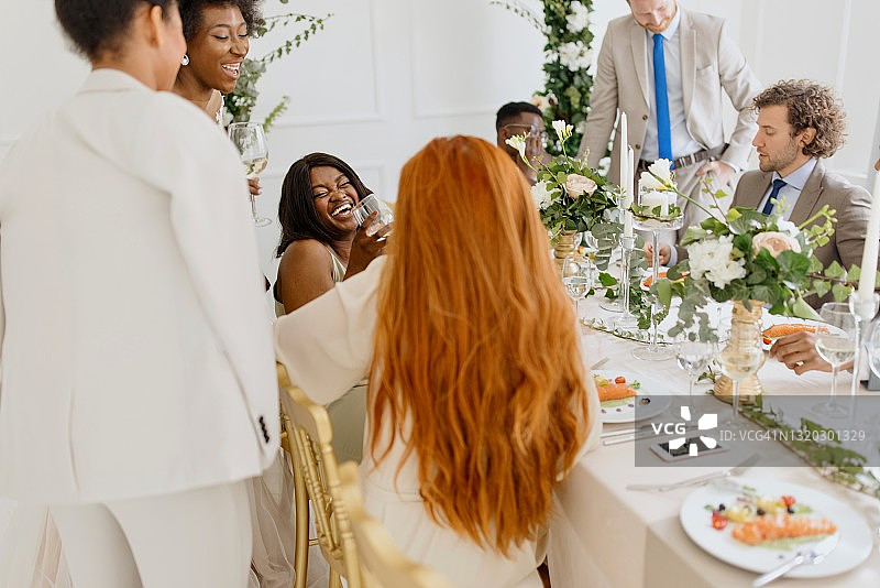 新婚夫妇和他们的朋友在婚宴上玩得很开心图片素材