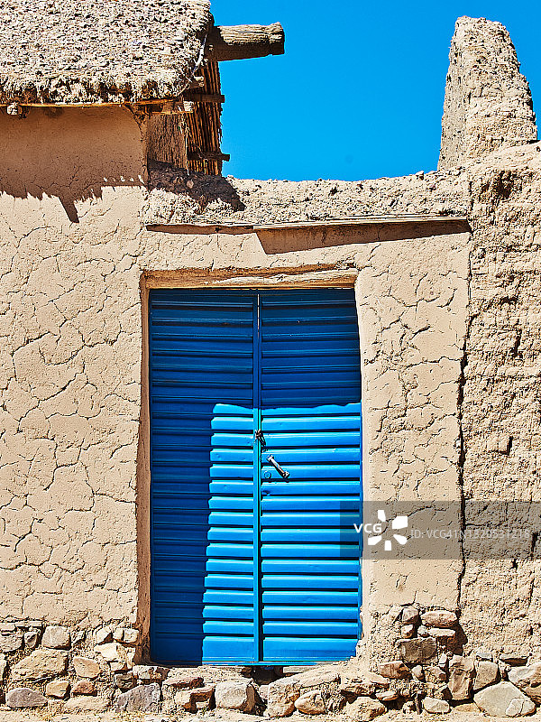 砖房的蓝色门。图片素材