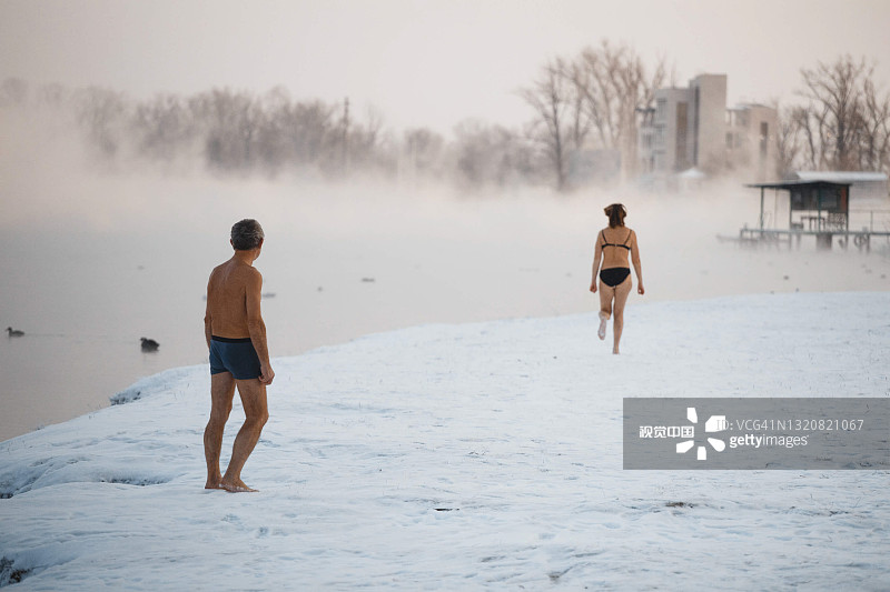 用冷水调温。冬天，人们在河边游泳。图片素材