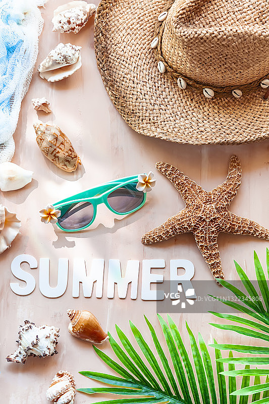 铭文夏天在白色的木头字母与棕榈树叶，草帽，贝壳，海星和太阳眼镜的背景。夏季海滩旅游概念。图片素材