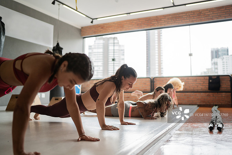 一群在健身房里做俯卧撑的妇女图片素材